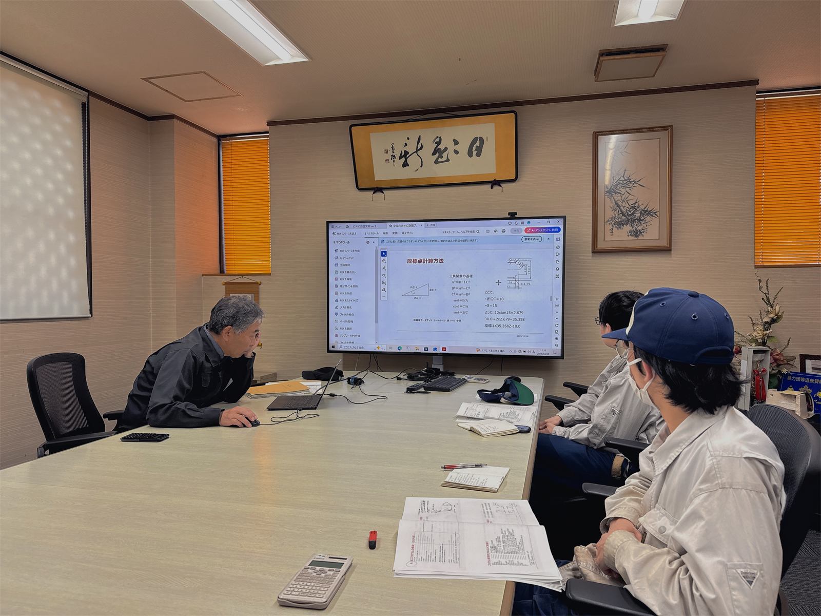 図面を見ながら打ち合わせする社員